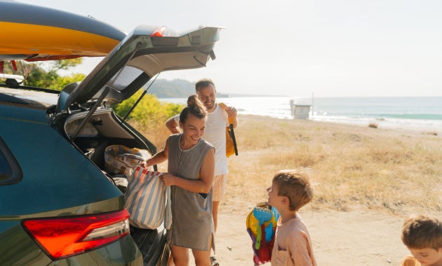 Family at the beach grabbing items from their vehicle